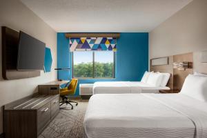 莫比尔提尔曼斯角莫拜尔西I-10智选假日酒店及套房的酒店客房设有两张床和一台平面电视。
