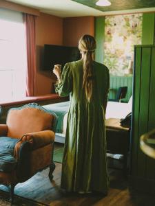 圣地亚哥Hotel Eco Boutique Bidasoa的站在房间里穿着绿色衣服的女人