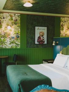 圣地亚哥Hotel Eco Boutique Bidasoa的一间卧室设有绿色的墙壁、一张床和一幅画