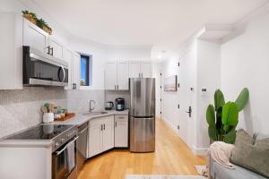 纽约1288-3RS New Renovated 2 Bedrooms的厨房配有白色橱柜和不锈钢冰箱