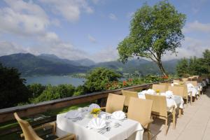泰根塞韦斯特霍夫山屋酒店的餐厅设有白色的桌椅,享有湖景