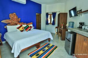 萨尤利塔Mar y Sueños Suites的一间卧室设有一张蓝色墙壁的大床