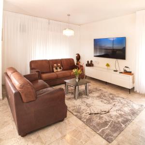 Giv‘ot MordekhayExclusive Jerusalem Villa的客厅配有棕色沙发和桌子