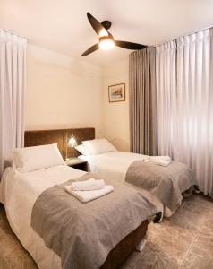 Giv‘ot MordekhayExclusive Jerusalem Villa的一间卧室配有两张床和吊扇