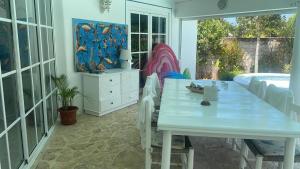 拉斯特拉纳斯Villa Del Mar的白色的用餐室设有桌子和游泳池