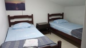 RoldanilloDeptos VILLA AURORA的一间卧室设有两张床和床头柜