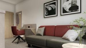 慕尼黑C & N Hotel - an der Messe München的带沙发和红色椅子的客厅