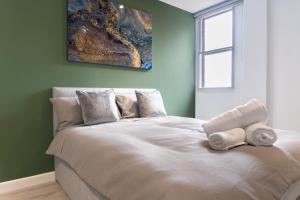 彼得伯勒Cross Street Suites by DH ApartHotels的一间卧室配有一张大床和毛巾