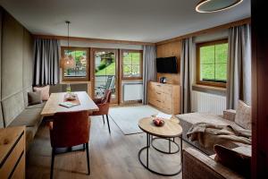 图克斯阿尔卑斯霍夫酒店的客厅配有桌子和沙发