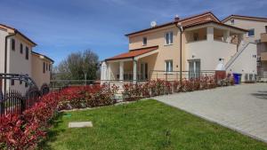 班约勒Ferienhaus mit Privatpool für 10 Personen ca 200 qm in Banjole, Istrien Istrische Riviera - b54844的一座带围栏和一些红花的房子