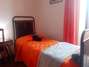 维托尔基亚诺Casetta dei Nonni的一间卧室配有一张带橙色棉被的床