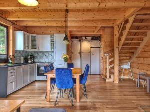拉普斯尼恩LK Resort Łapsze domy z prywatną balią i sauną的厨房配有木桌和蓝色椅子