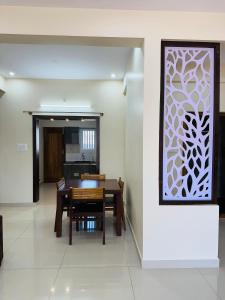 迈索尔Oryx Residences - Luxury Serviced Apartments的一间设有桌子和白色墙壁的用餐室