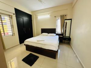 迈索尔Oryx Residences的一间卧室配有一张床和镜子