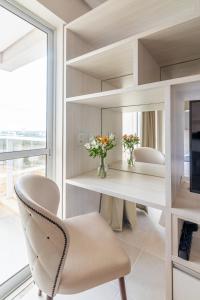 帕尔马斯PALMAS EXPERIENCE - FLAT PÔR DO SOL, vista panorâmica, melhor localização的窗户客房内的一张桌子和一把椅子