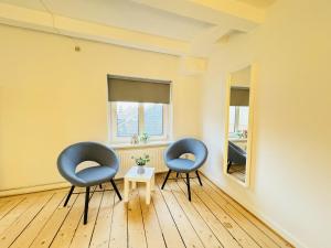 兰讷斯aday - Randers Beautiful Central 2 bedrooms Apartment的两个蓝色的椅子和一张桌子