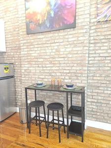 纽约The Harlem Getaway的砖墙房间里一张桌子和两张凳子
