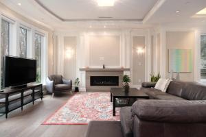 温哥华Luxurious 6-Bedroom Mansion Near UBC的带沙发和电视的客厅