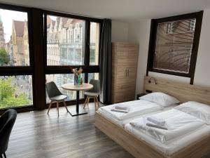 纽伦堡NB Apartments的一间卧室配有一张床和一张桌子及椅子