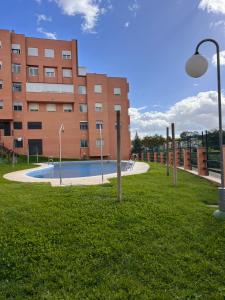 卡马斯Apartamento Jardín de Atalaya的建筑前的一座带游泳池的建筑