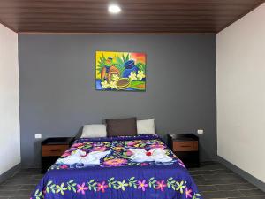 莫约加尔帕Hostal Mamá Derlys的卧室配有一张床,墙上挂有绘画作品