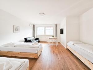 杜塞尔多夫RAJ Living - 2 or 3 Room Apartments - 15 Min zur Messe DUS & 10 Min Old Town DUS的白色客房 - 带两张床和椅子