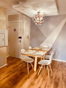 佩洛塔斯Apartamento Acqua, 102 A, com vaga de garagem的餐桌、白色椅子和吊灯