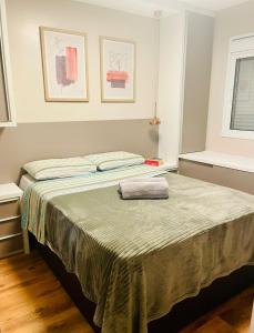 佩洛塔斯Apartamento Acqua, 102 A, com vaga de garagem的一间卧室配有一张床,床上有毛巾
