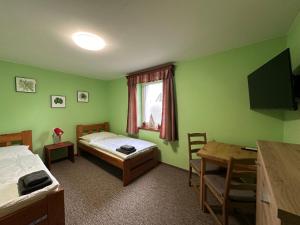 斯姆尔克山麓新城Ubytování Smrk的客房设有两张床、一张桌子和一张书桌。