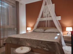 法扎纳Apartment Luka的一间卧室配有一张带天蓬和窗户的床