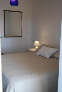 帕洛港2 bedrooms apartement with sea view furnished terrace and wifi at Porto Palo 1 km away from the beach的卧室配有一张床,墙上设有镜子