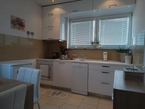 法扎纳Apartment Luka的一间厨房,配有白色的橱柜和大窗户