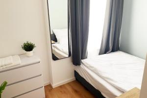 门兴格拉德巴赫Großzügiges City-Apartment in Mönchengladbach的一间小卧室,配有一张床和镜子