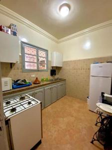 马拉喀什Dar Baddi的厨房配有炉灶和白色冰箱。