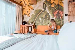 博卡斯德尔托罗Bambuda Bocas Town的坐在卧室里橙色沙发上的女人