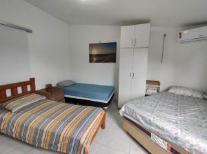 巴雷里尼亚斯Chalé em Porto dos Lençóis Residence的一间卧室配有两张床、一个橱柜和一张床