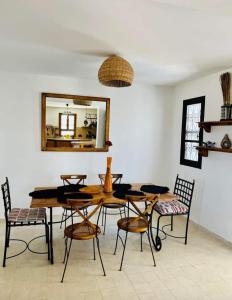 乌姆苏克Dar Cristina的一间带桌椅和镜子的用餐室