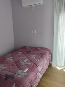 雷孔基斯塔Los naranjos的一张床位,位于带粉红色棉被的房间