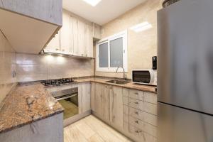 库尼特Mar & Cunit的厨房配有木制橱柜和冰箱。
