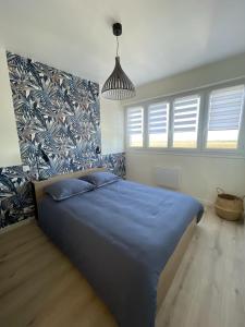 热夫雷尚贝尔坦La Maison Fonteny, Gevrey Chambertin的一间卧室配有一张带蓝色床单的大床