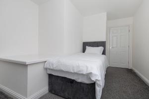 巴特利New Build 4 bed Det House in Yorkshire Nr Leeds的白色卧室配有一张带白色毯子的床
