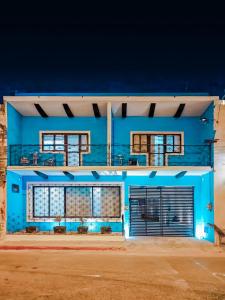 梅里达Casa Kuxul的蓝色的建筑,晚上有两扇车库门