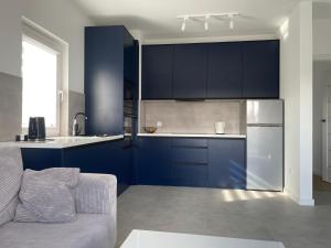 兰卡特Apartament Skłodowskiej的厨房配有蓝色橱柜和银色冰箱