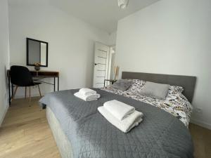 兰卡特Apartament Skłodowskiej的一间卧室配有带毛巾的床