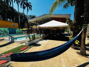 拉利伯塔德LA CASONA SV的度假村前方的蓝色吊床,设有游泳池