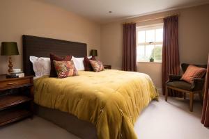 West WoodburnRisingham House的一间卧室配有一张带黄色床罩的床和窗户