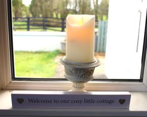 诺克Heather Cottage and Shepherds Hut的窗前窗台上的蜡烛