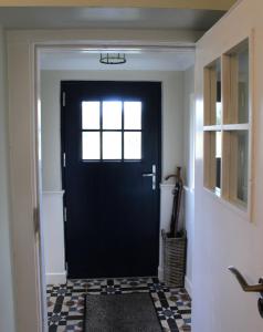 诺克Heather Cottage and Shepherds Hut的走廊上设有黑门,设有 ⁇ 格地板