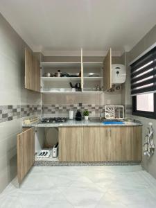 胡塞马Mini villa Al hoceima的一间带木制橱柜和微波炉的厨房
