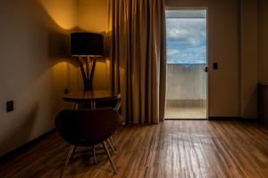 卡夸尔Catuai Hotel的客房设有桌子、椅子和窗户。